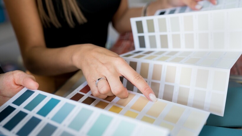 Close-up of two interior decorators choosing samples of wall paint