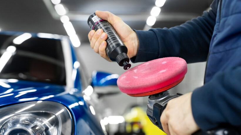 Car polish vs wax - A person applying a car wax on a polishing tool