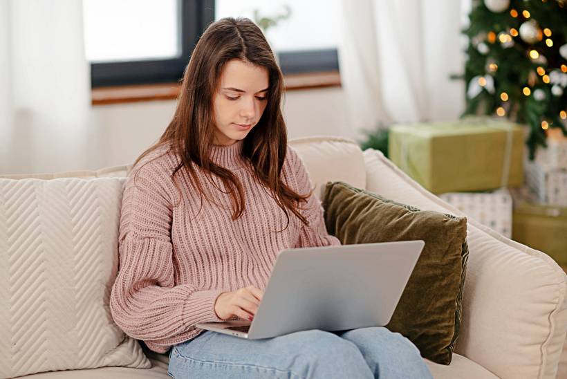 getting ready for the holidays - a woman sitting on a sofa near a Christmas tree