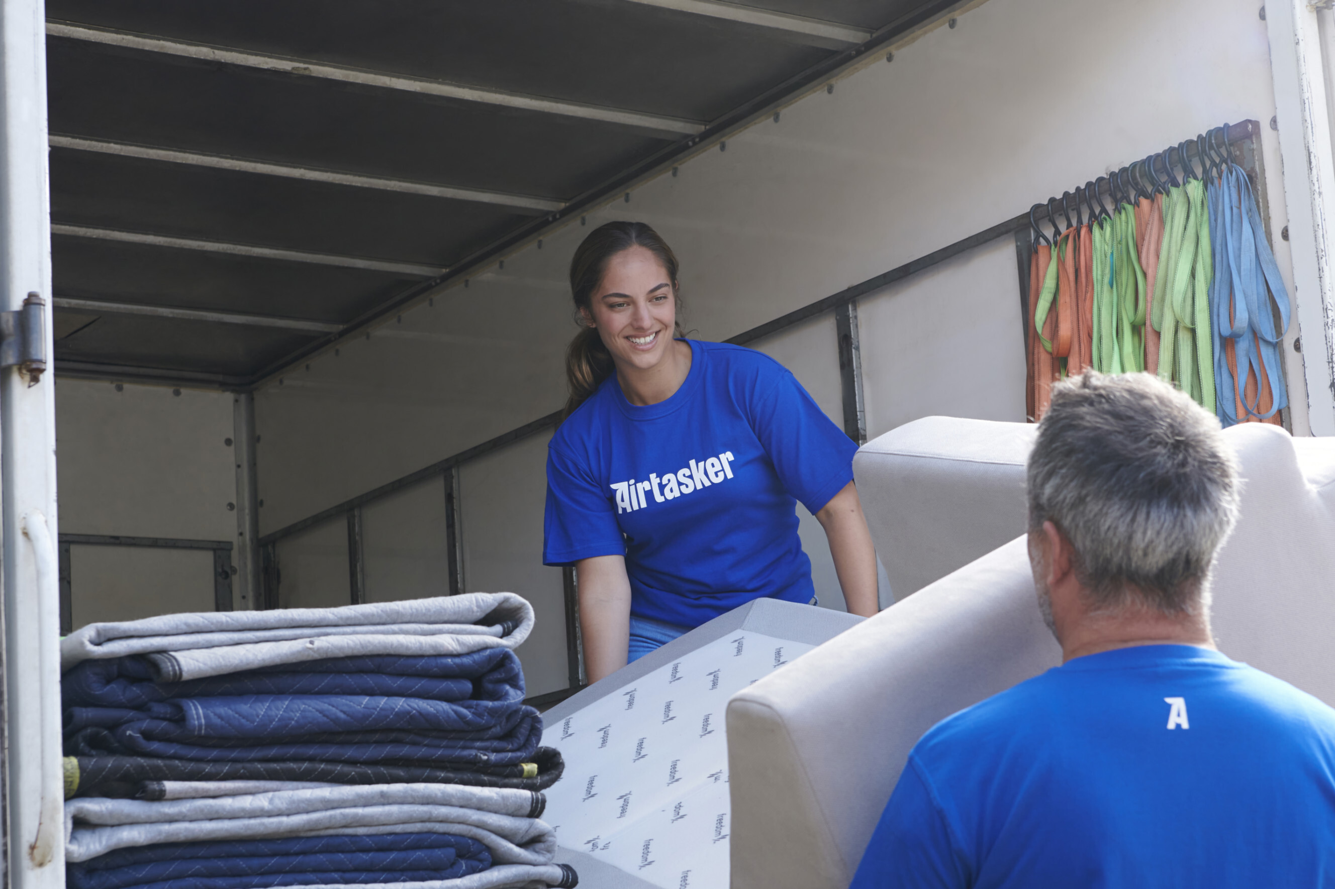 Friendly long-distance movers loading furniture into a truck, highlighting professional long-distance moving services near you.