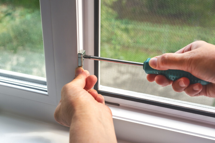 window screen installation - Tightening the fasteners of a window screen for secure installation.