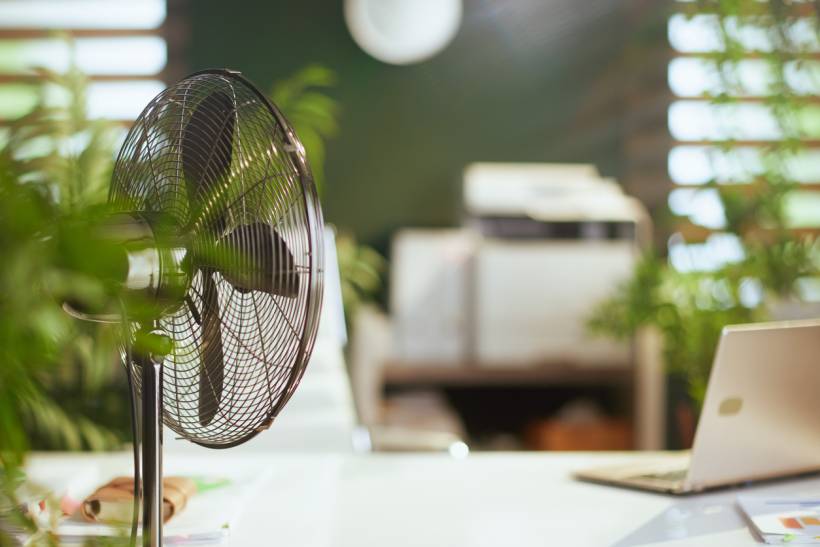 How to stop dust from collecting on desk - an electric fan on a clean desk