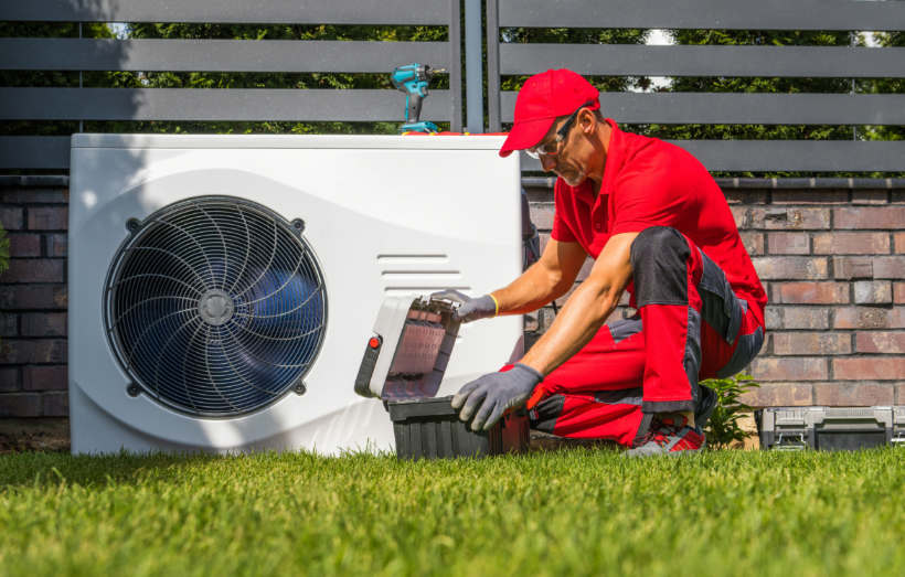 Air conditioner installation cost - Maintenance worker performing routine air conditioning repairs.