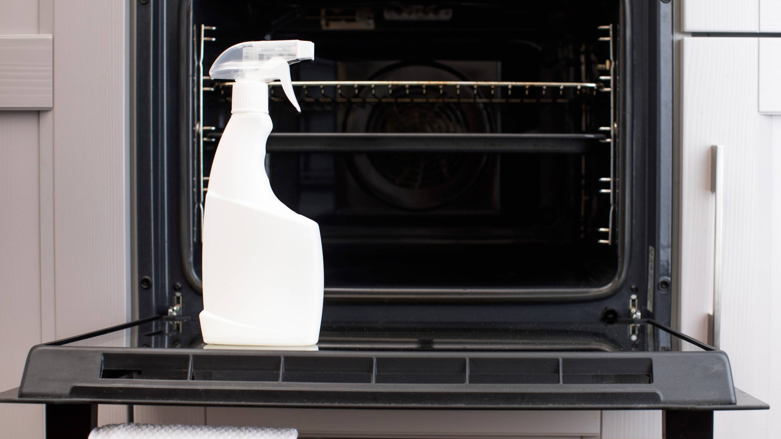 a bottle of detergent on top of an oven's door