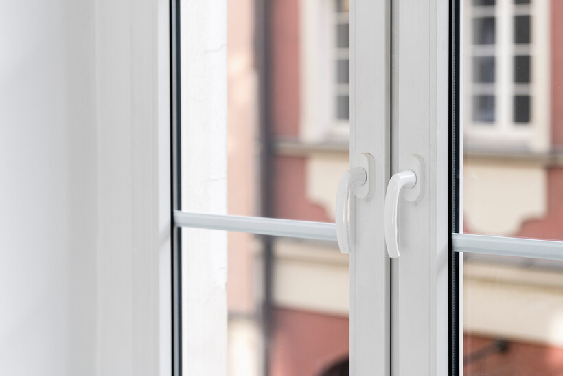 Close-up of uPVC window with two handles and reflective glass. - upvc vs aluminum windows
