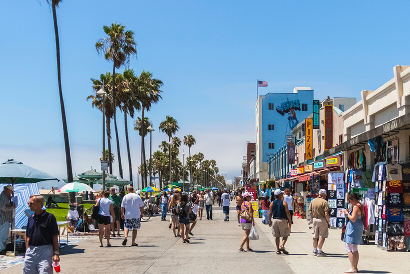 A scenic view of the blue ocean and sandy shore near the boardwalk. - moving to Los Angeles