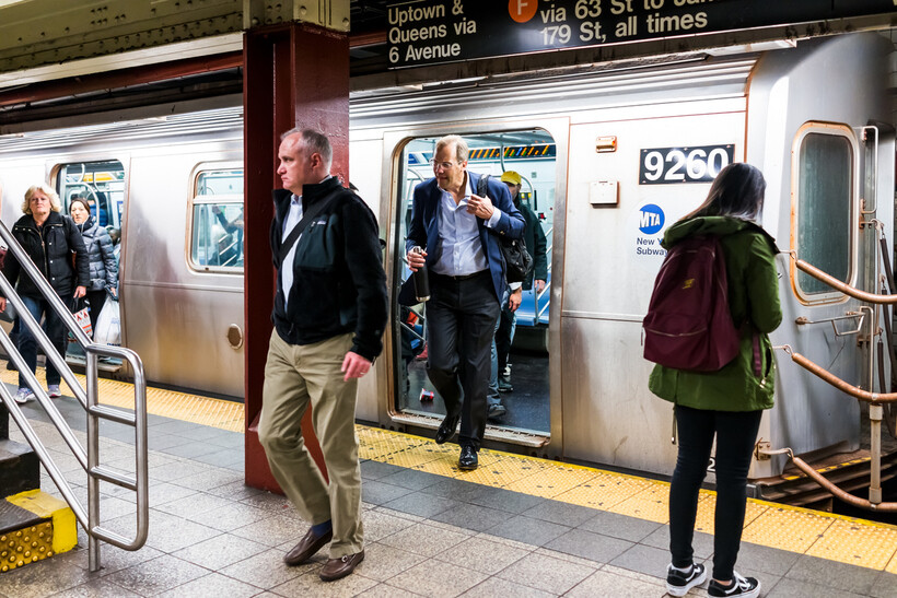A busy underground subway station with people walking and waiting for transit. - how to move to New York