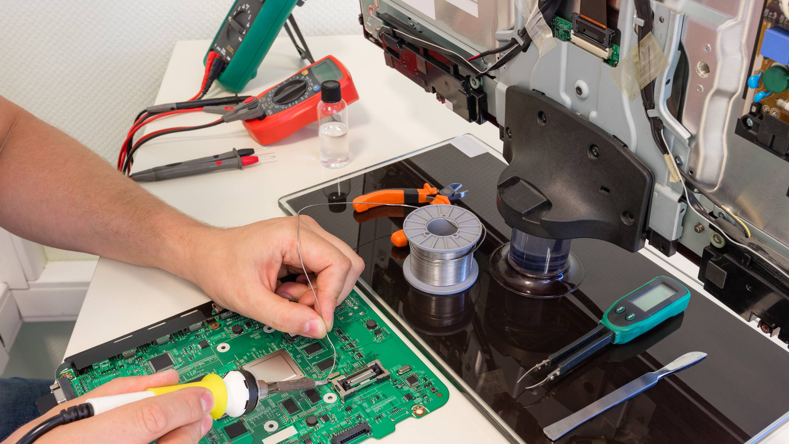 A technician repairing a damaged TV