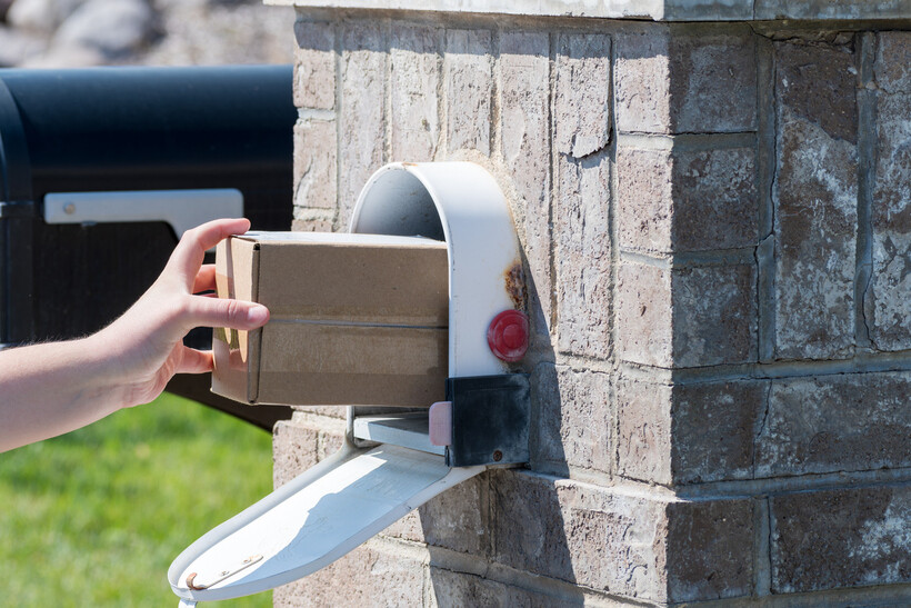 Package delivery placed securely inside a large black mailbox during winter. - how to replace a mailbox