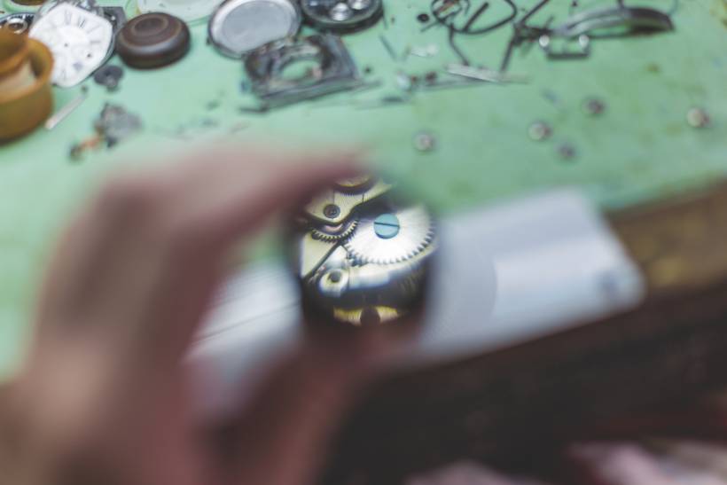 how much does clock repair cost - Blurred foreground with focused view of gears inside a clock