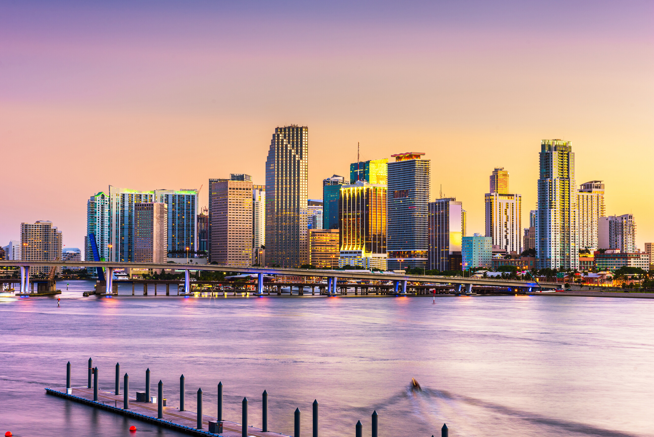 A wide panoramic view of the Miami Florida skyline along the calm Biscayne Bay.