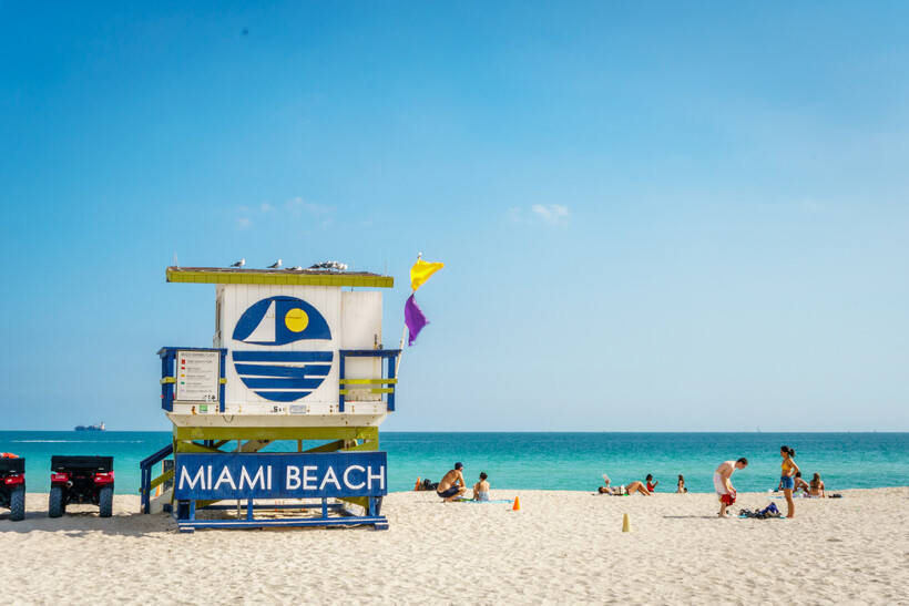 A colorful Art Deco lifeguard tower standing on the white sands of Miami Beach. - moving to Miami