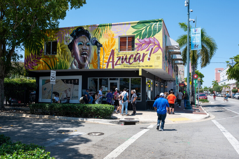 A vibrant Calle Ocho street scene in Little Havana with palm trees and colorful buildings. - moving to Miami