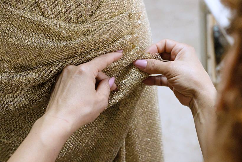 dress alterations cost - Dress alterations in progress on a gown made from textured gold fabric