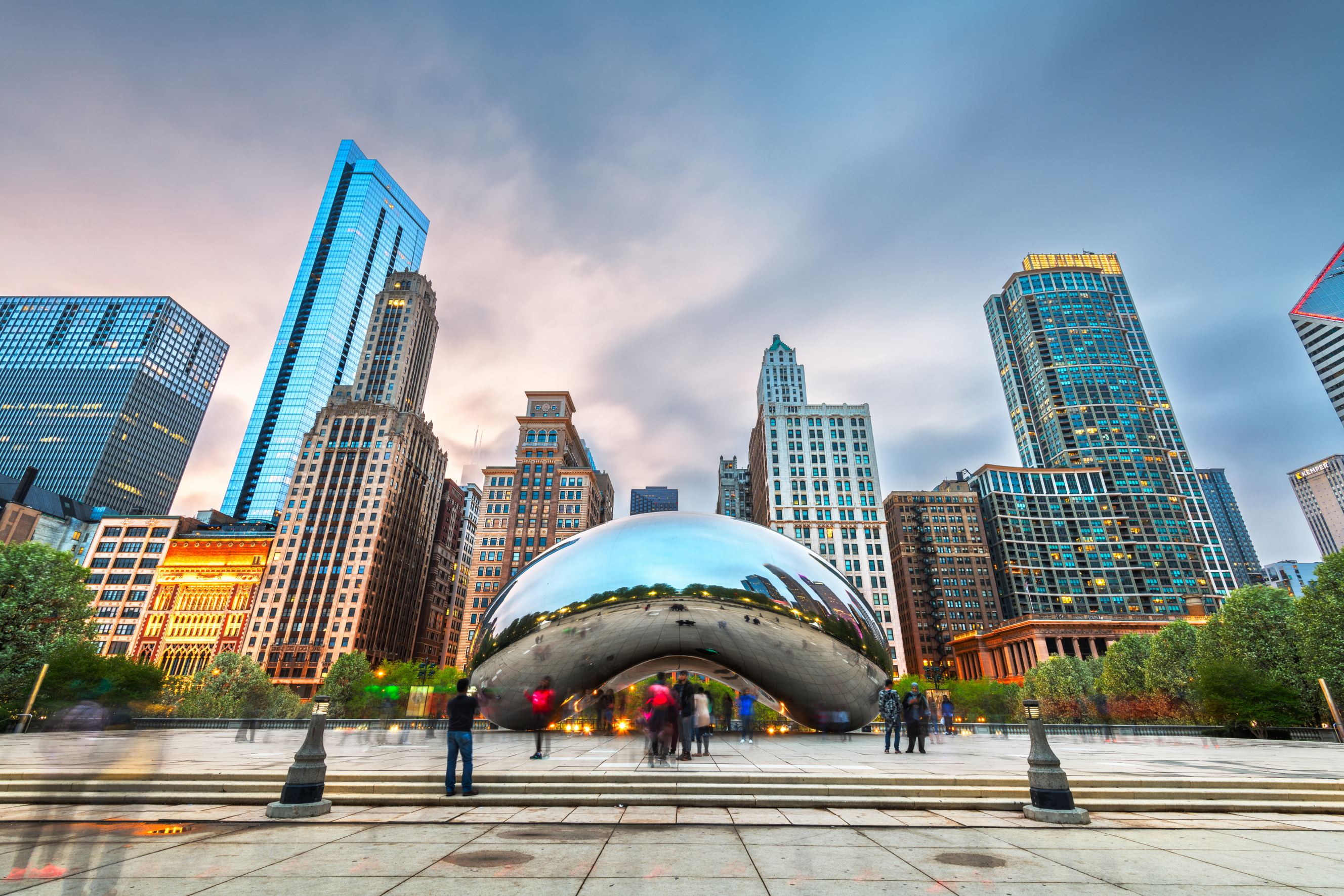 Tourists visit Cloud Gate in Millennium Park, Chicago in the evening. 