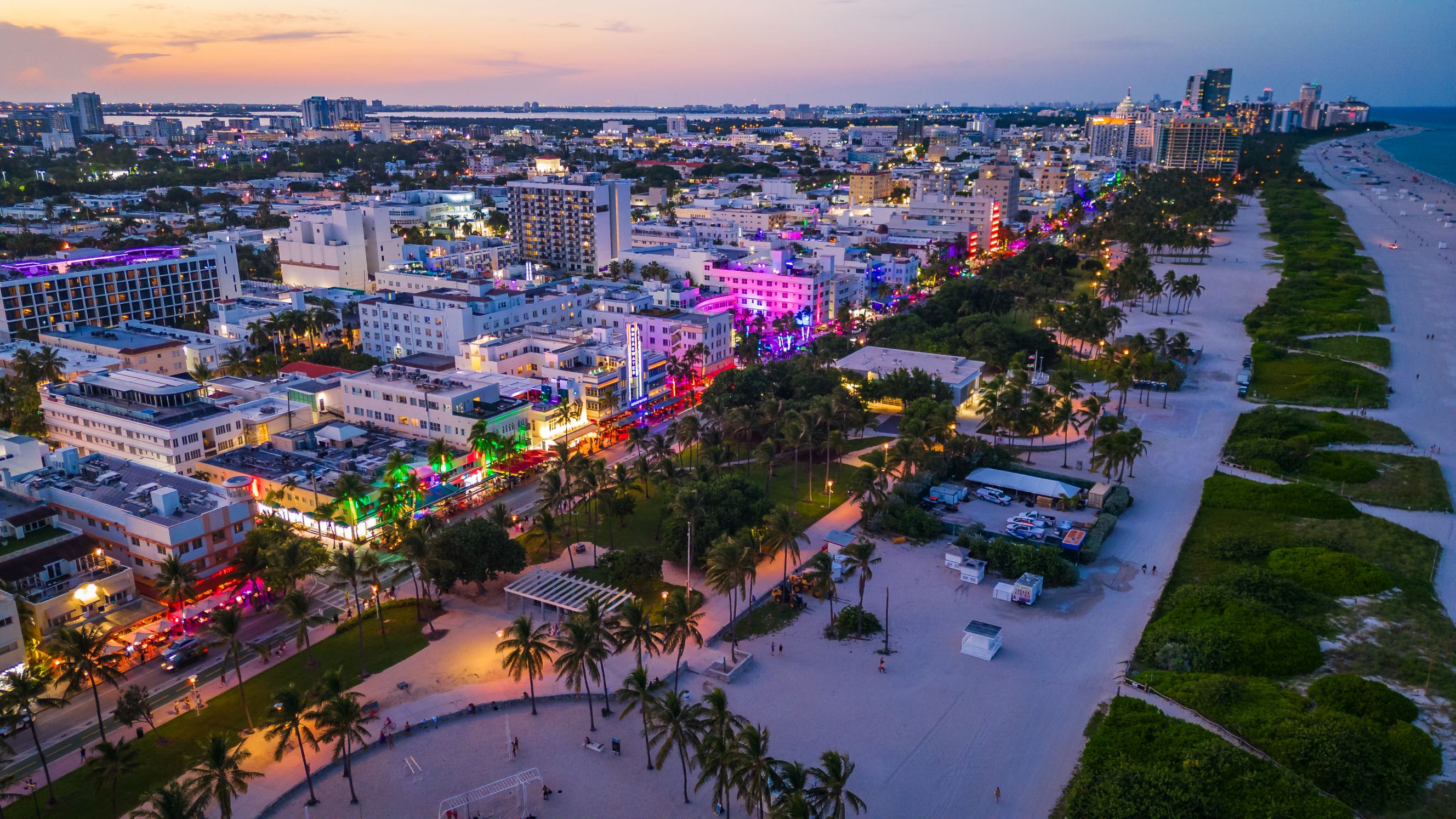Aerial of Miami South beach illuminated at night with sunset.