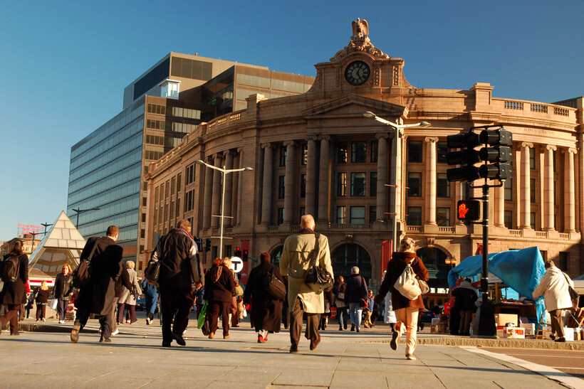 Pedestrians crossing a busy street near South Station in downtown Boston. - moving to Boston