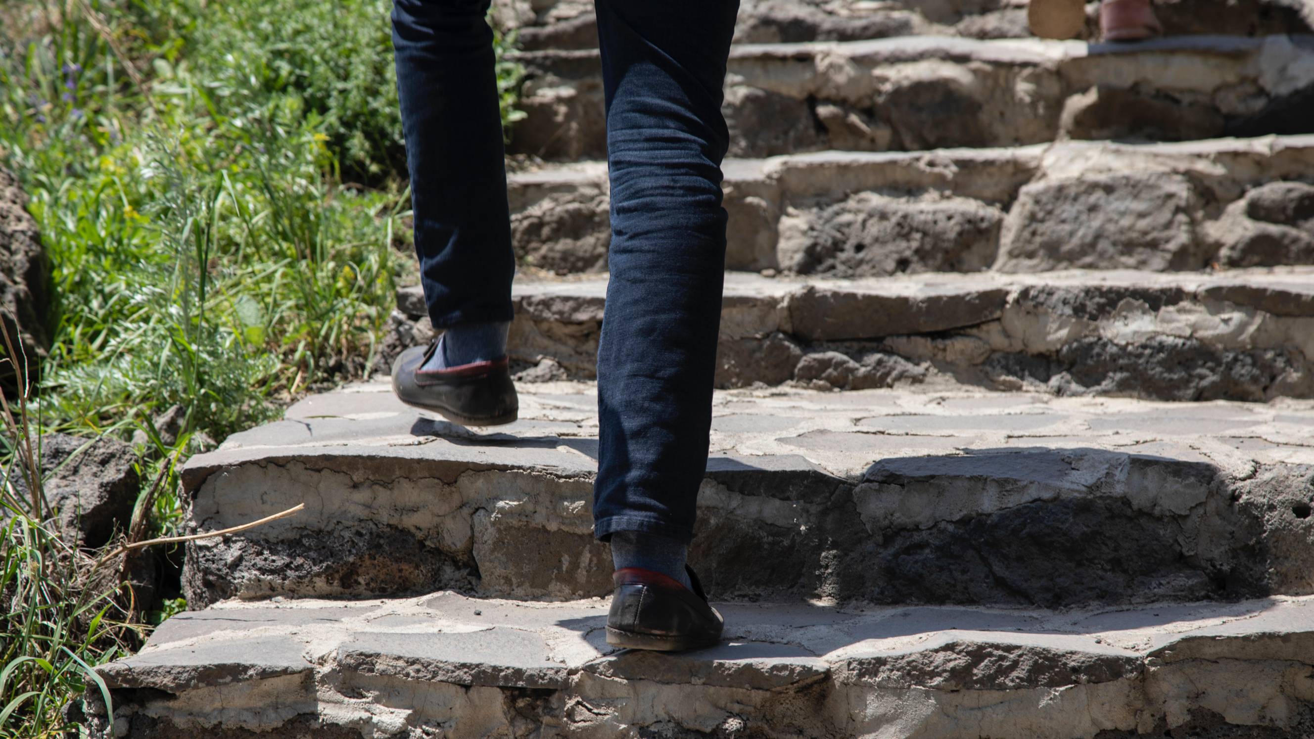 man climbing concrete steps in a garden