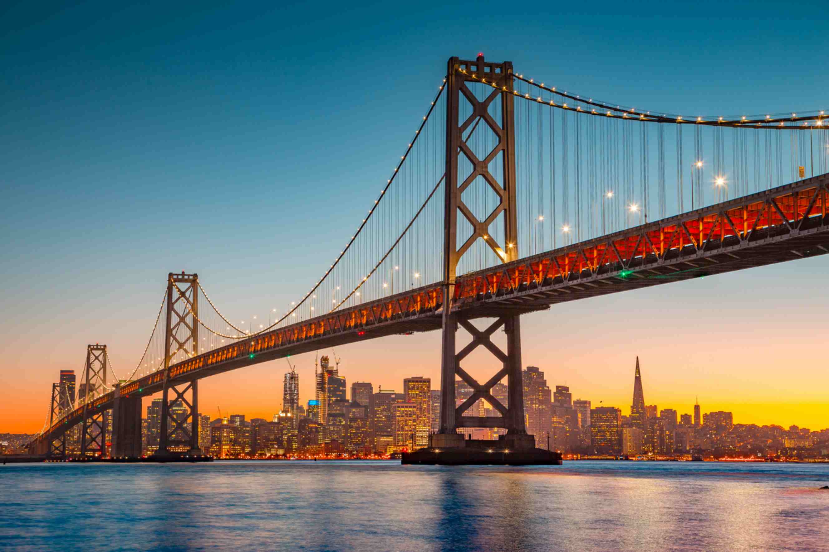 San Francisco skyline at sunset with the Bay Bridge, a popular destination for people moving from NYC to SF