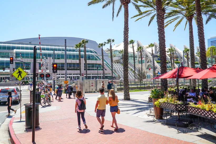A view of the modern San Diego Convention Center architecture with green palm trees. - moving to San Diego