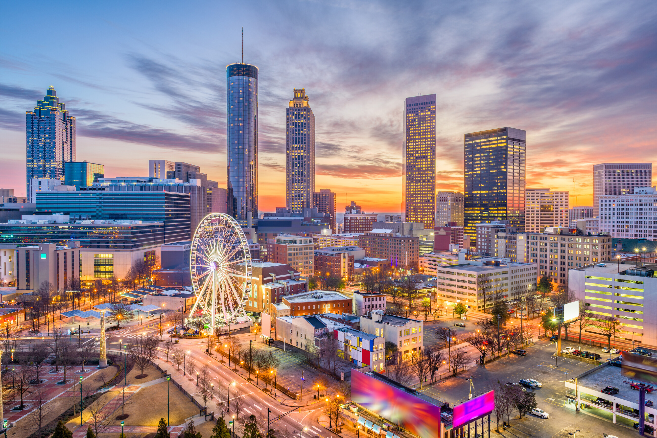 Downtown Atlanta cityscape with illuminated high-rise buildings at dusk.