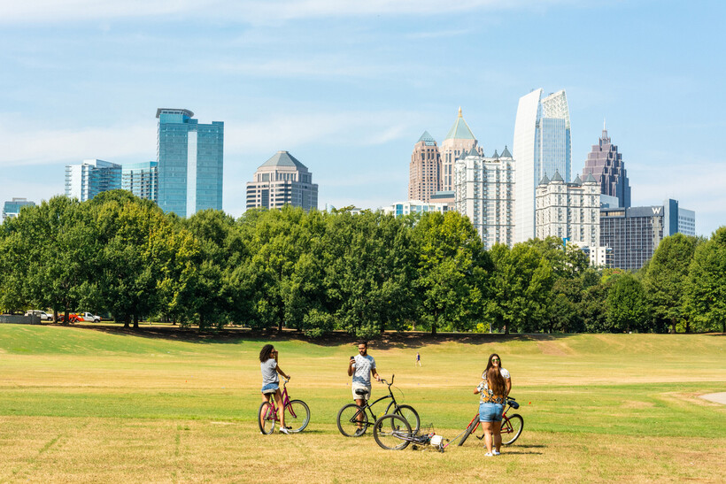 Midtown Atlanta skyline rising above tree-lined streets and city buildings. - moving to Atlanta