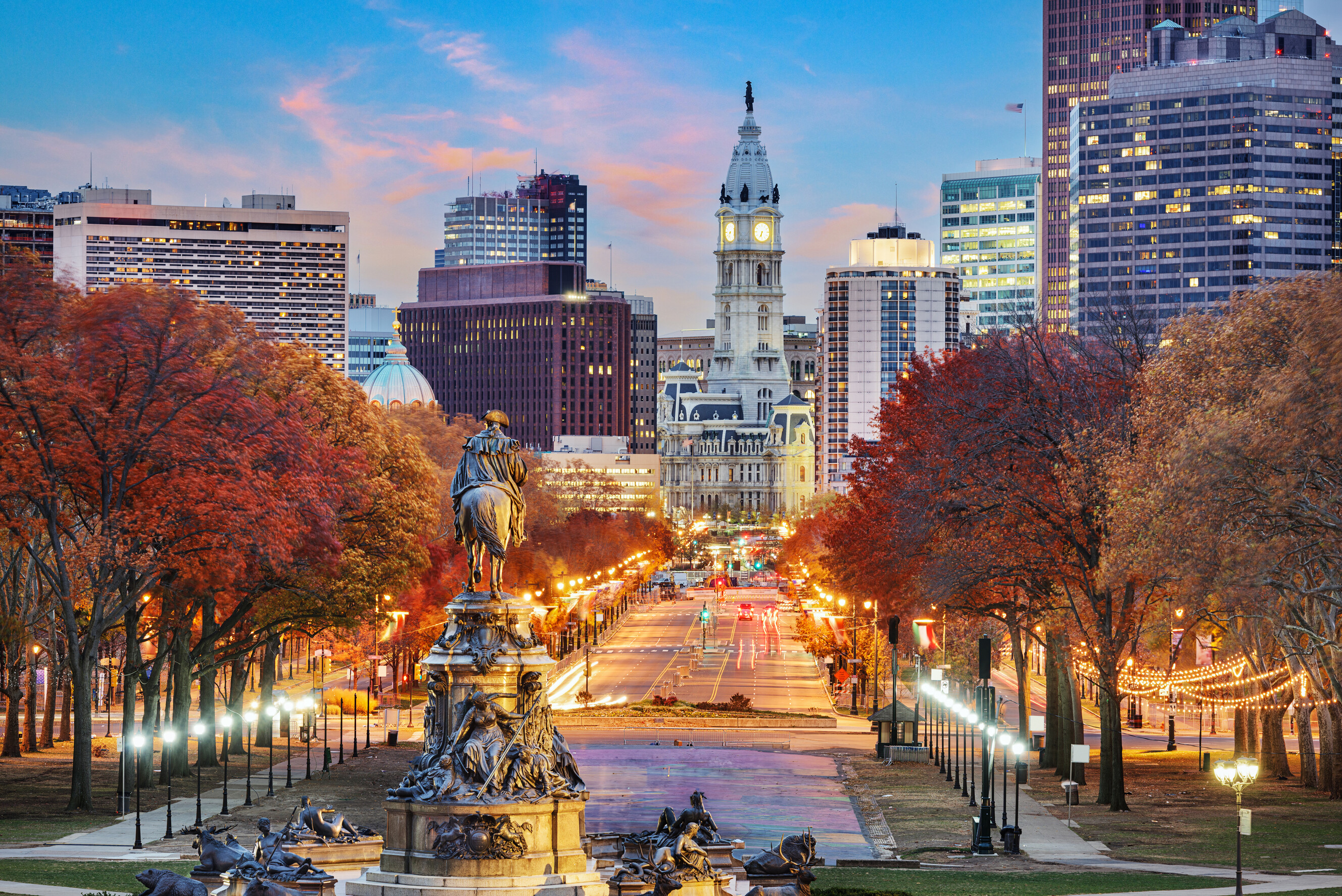 A wide cityscape view overlooking the Benjamin Franklin Parkway in downtown Philadelphia.