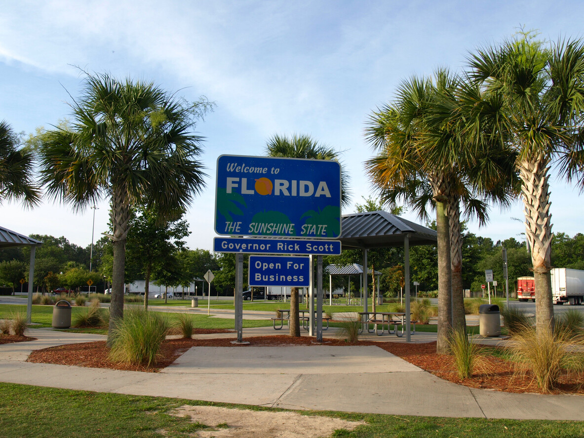 Welcome to Florida roadside sign surrounded by palm trees