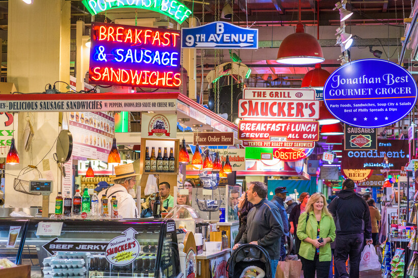 Crowds of people exploring the various food stalls at a Philadelphia market. - moving to Philadelphia