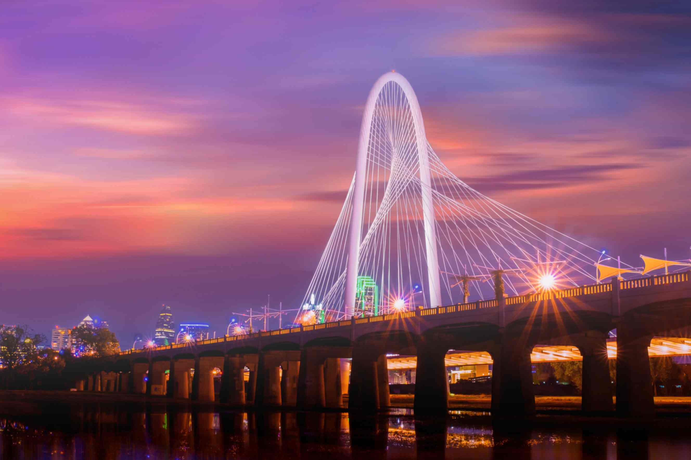 Dallas skyline with Margaret Hunt Hill Bridge at sunset, a popular destination for people moving from Chicago