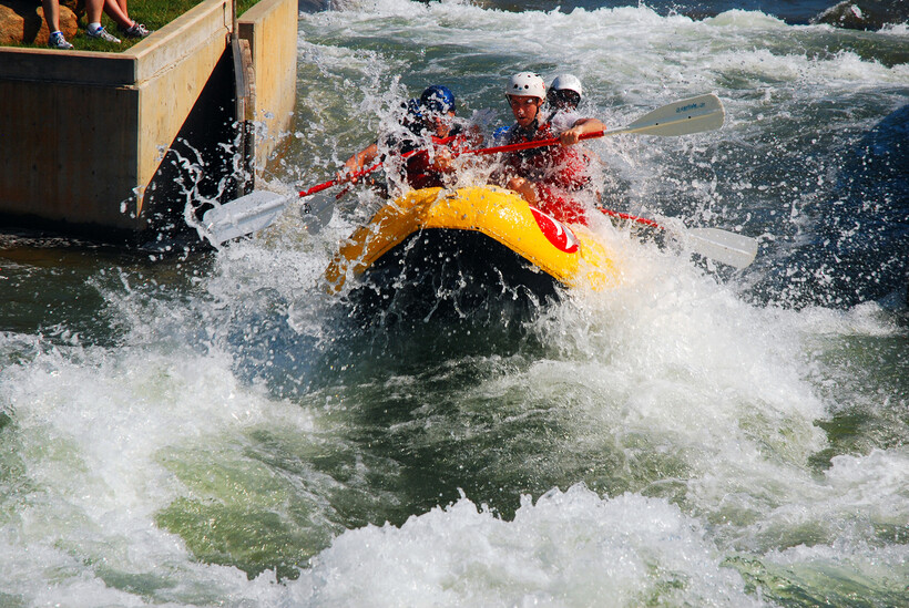 A group of rafters riding through rushing whitewater rapids in Charlotte. - moving to Charlotte NC