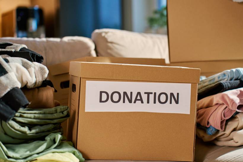 how much does decluttering cost - Cardboard donation box with sorted clothing during decluttering