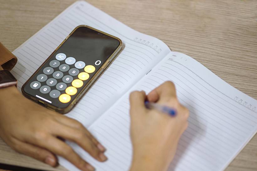 iPhone repair cost - iPhone calculator on open notebook for cost planning