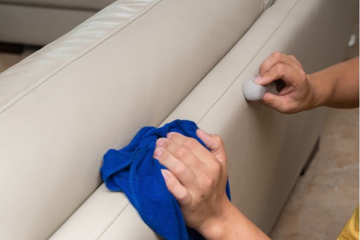 cleaning leather sofa with sponge and towel