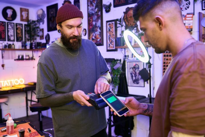 Client making a contactless payment and tip at a tattoo studio