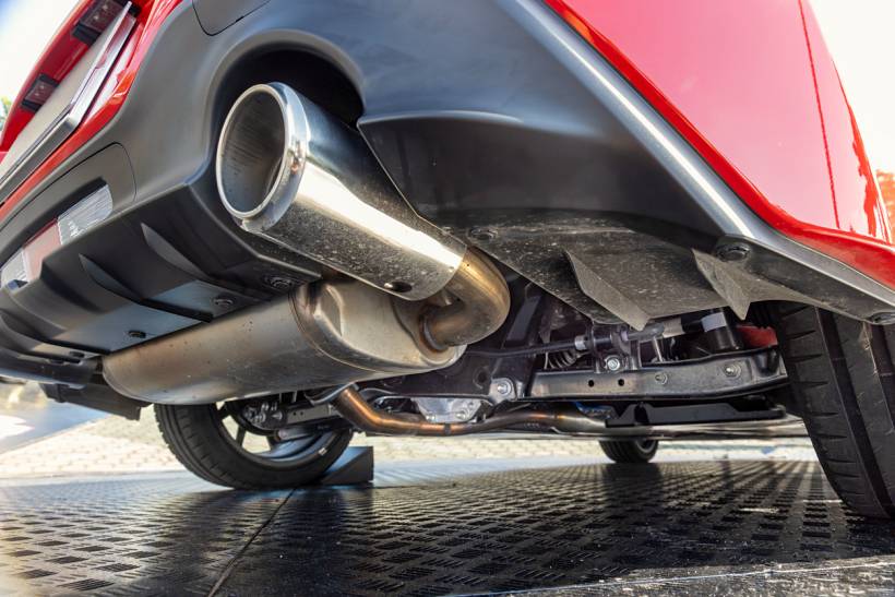 diesel particulate filter replacement cost - Car exhaust assembly viewed from beneath red rear bumper