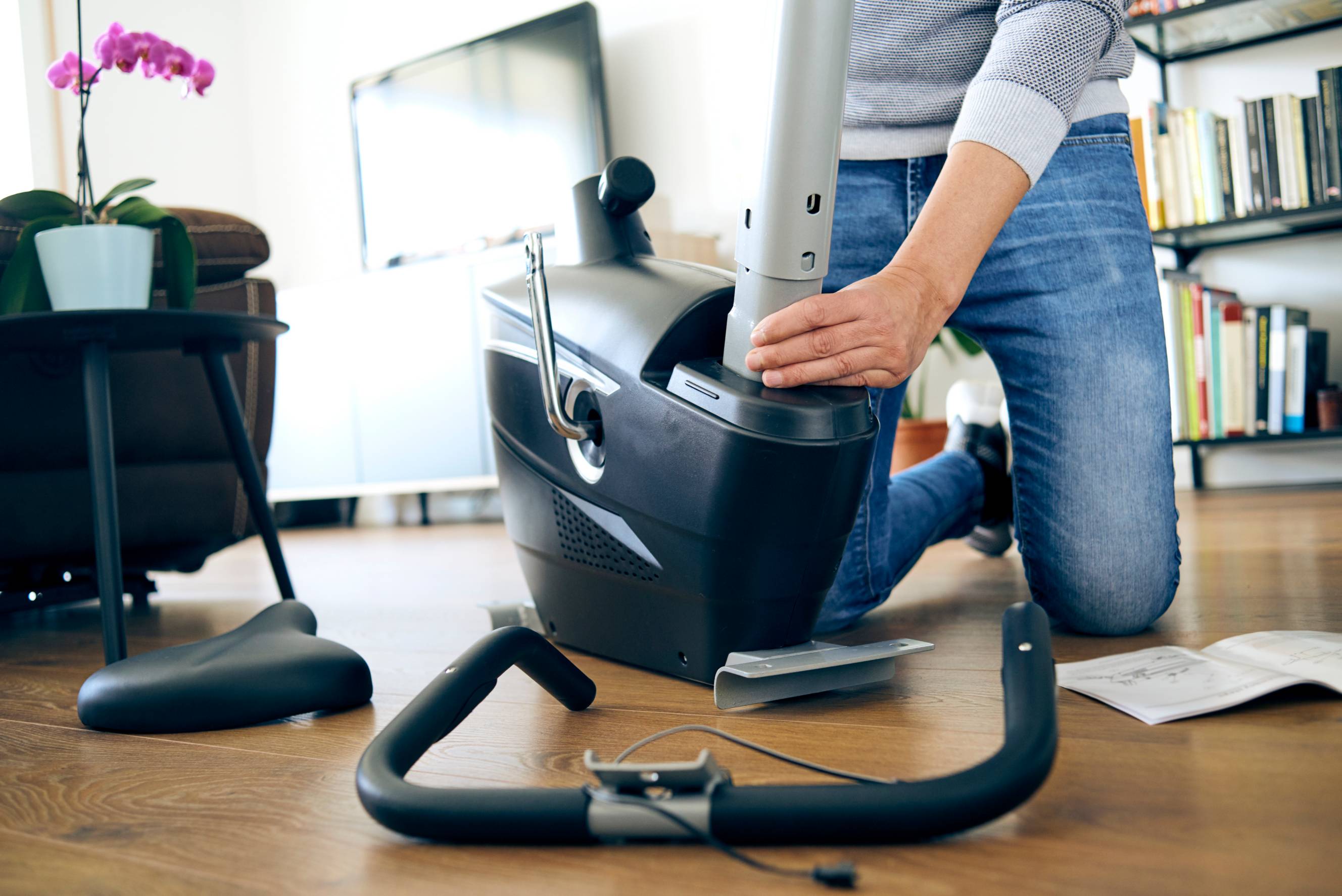 A person disassembling an exercise bike in preparation for Peloton moving