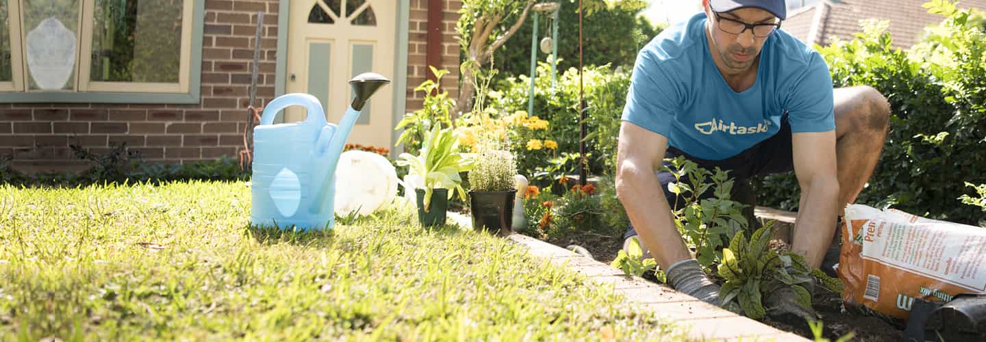 a closeup photo of a gardener mowing a lawn